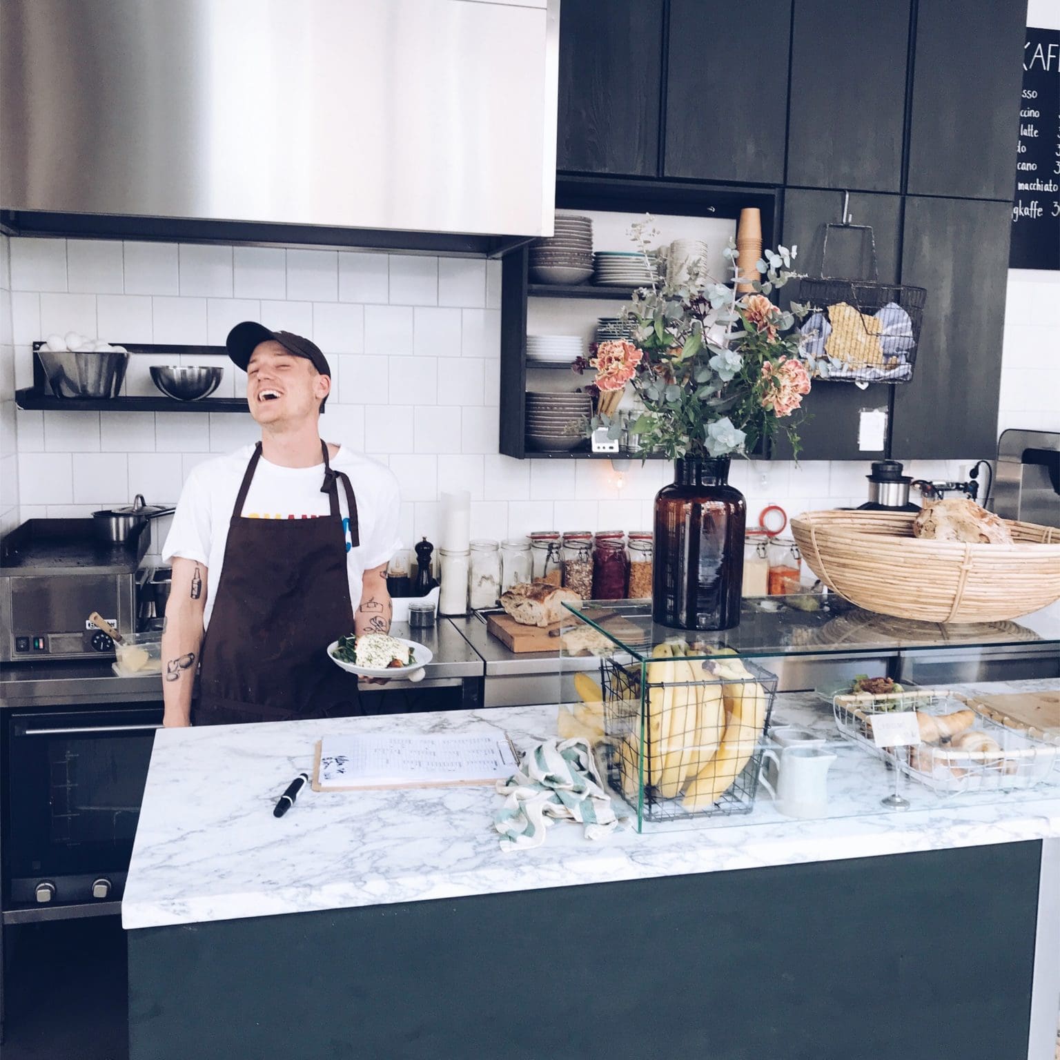 A man standing in front of a counter in a kitchen.