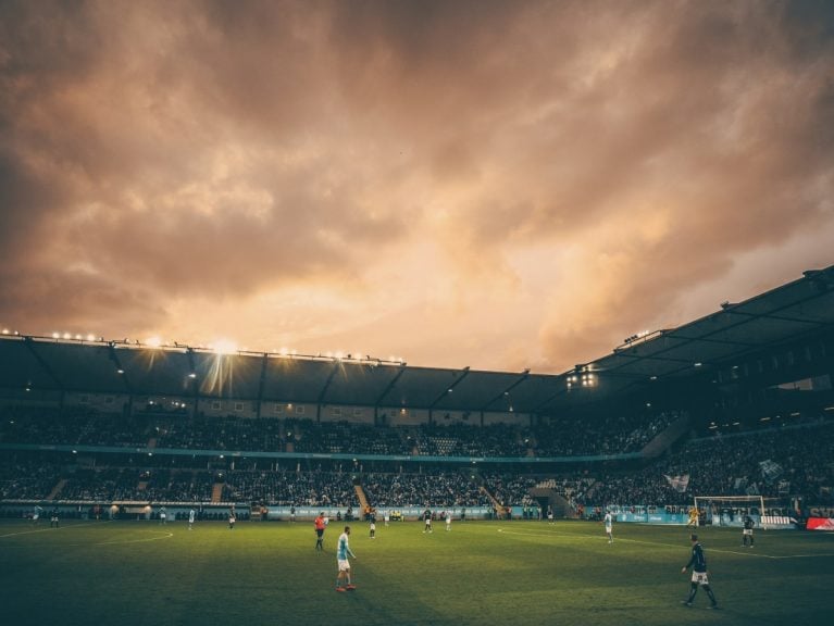 A soccer stadium with a cloudy sky in the background.