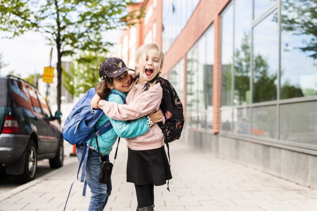 hugging and laughing by school