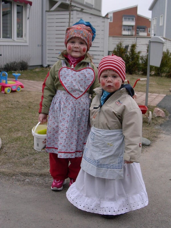 Two children dressed up in aprons and hats.
