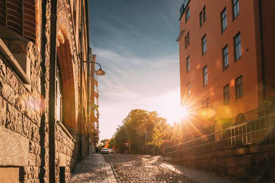 The sun is shining on a cobblestone street in stockholm, sweden.