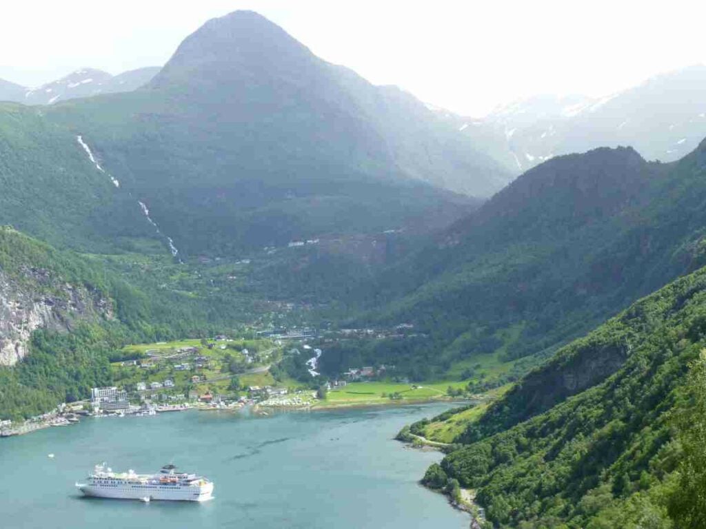 A cruise ship is in the middle of a body of water.